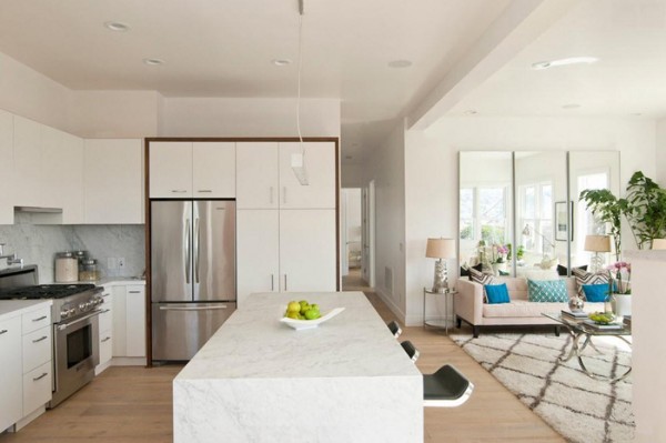 Современный интерьер кухни-гостиной в частном доме в белом цвете