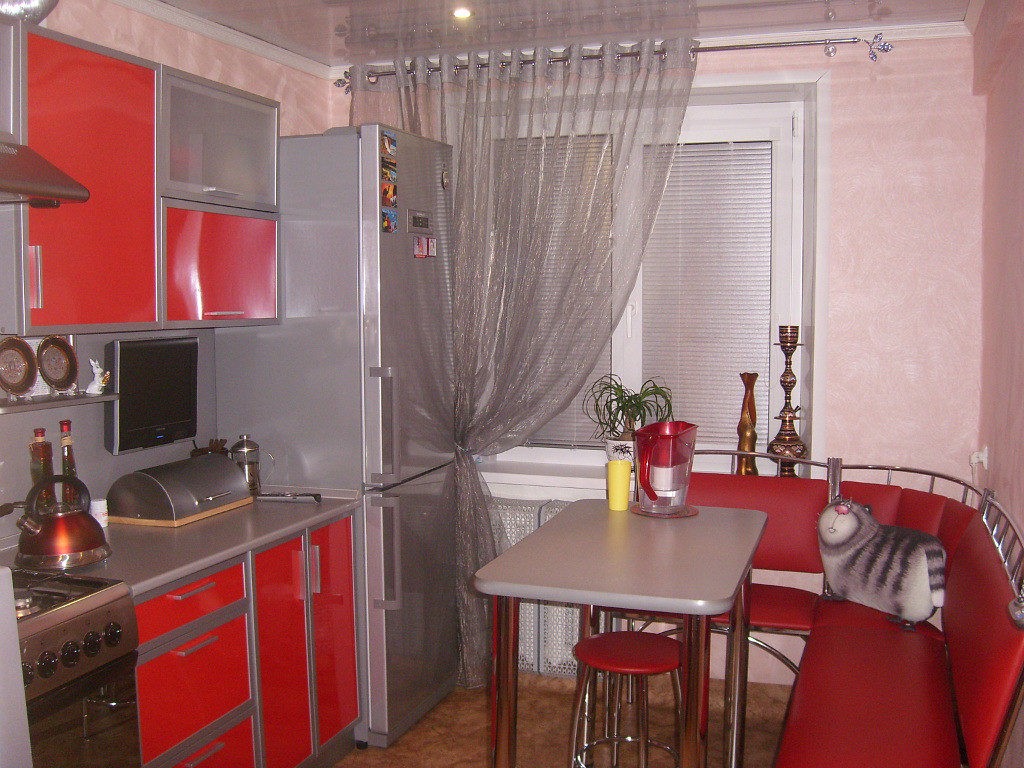 Серый холодильник в кухне с красными фасадами