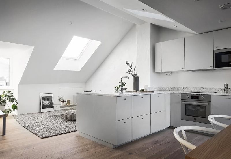 Белая кухня в мансарде частного дома в минималистическом стиле