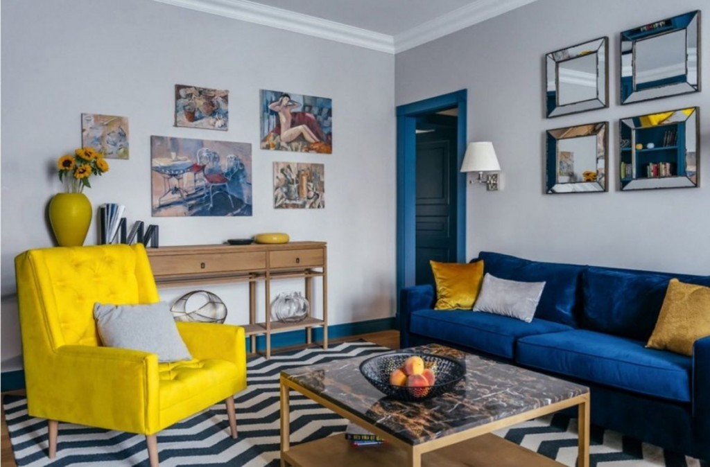 Синий диван в зале с желтым креслом