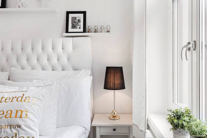 белая кровать с высоким мягким изголовьем в маленькой спальни
