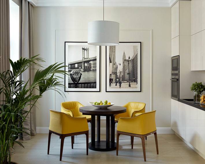 ярко-желтые стулья за обеденным круглым столом на кухне фото