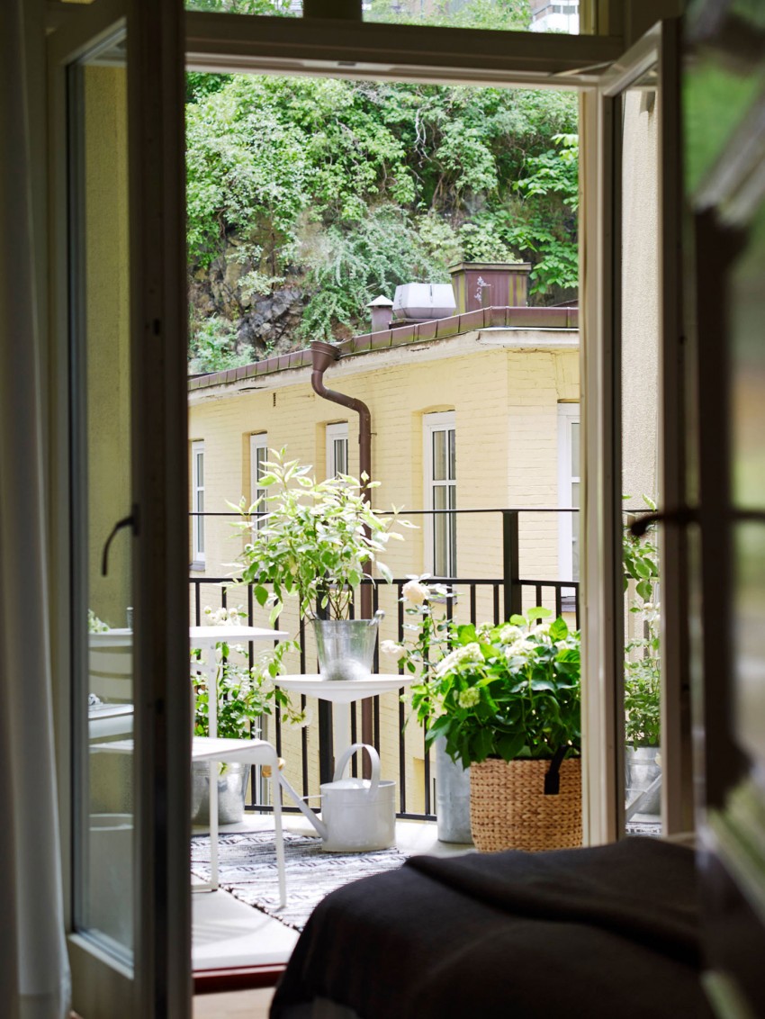 Французское окно спальни с видом на городскую улицу в интерьере квартиры в скандинавском стиле