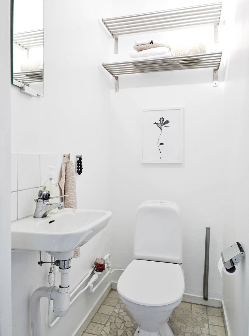 Белая керамическая плитка в интерьере уборной квартиры в скандинавском стиле