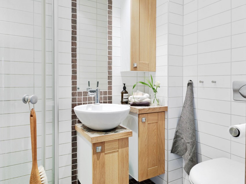 Шкафчики из светлого дерева в интерьере ванной квартиры в скандинавском стиле