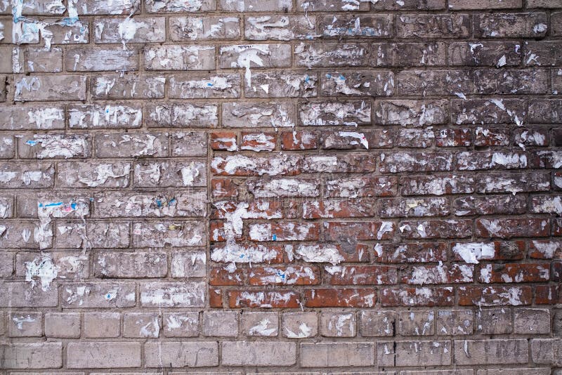 Old brick wall of the house with the torn-off ads. Texture. royalty free stock images