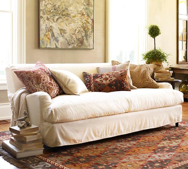 Квадратные подушки с принтом лежат на диване в красивой комнате