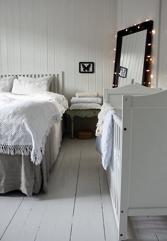 Интерьер в белых тонах в спальне с детской кроваткой